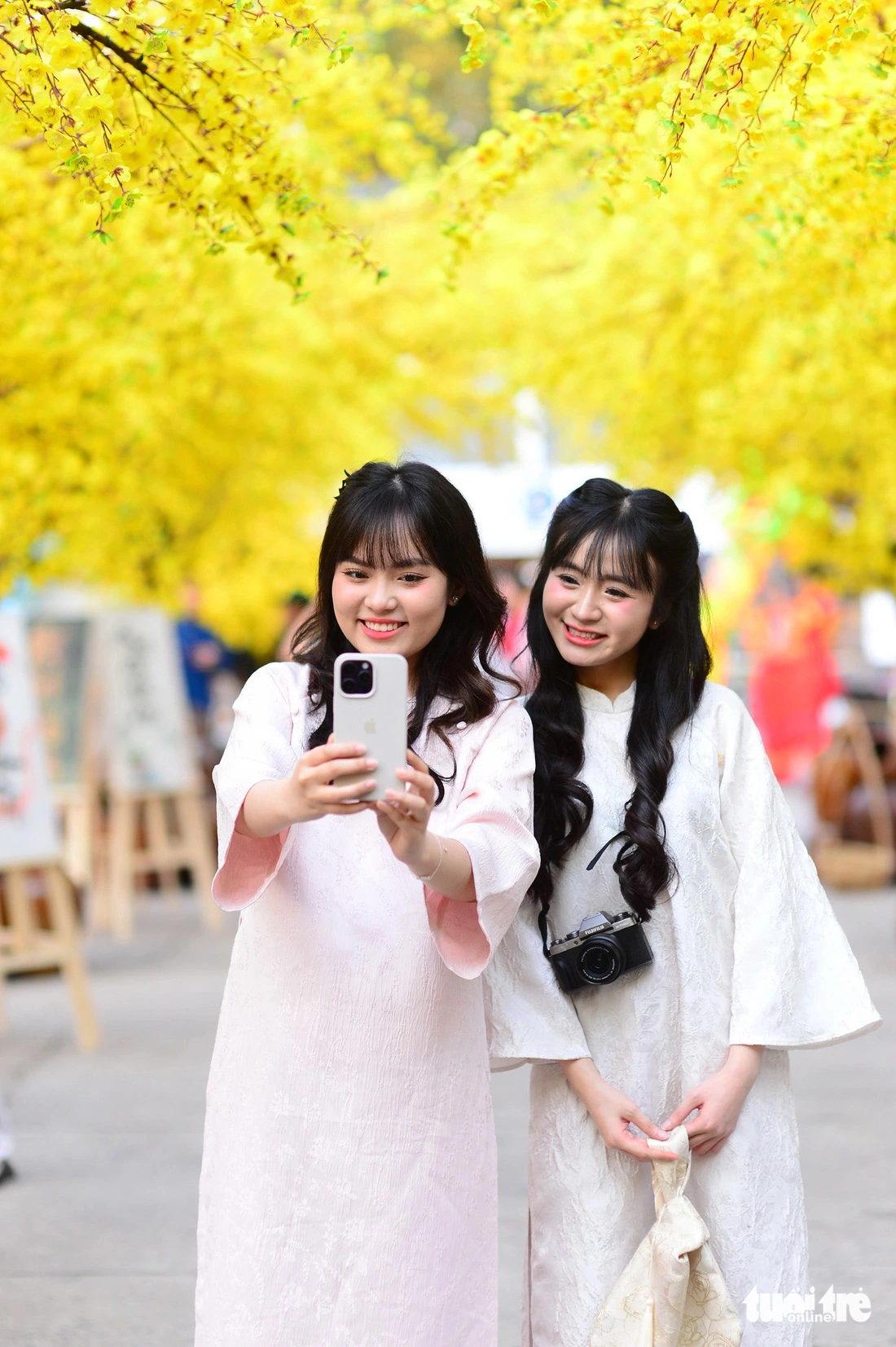 Two girls in ‘ao dai’ at the 2025 Vietnamese Tet Festival at the Youth Culture House in Ho Chi Minh City, January 13, 2024.