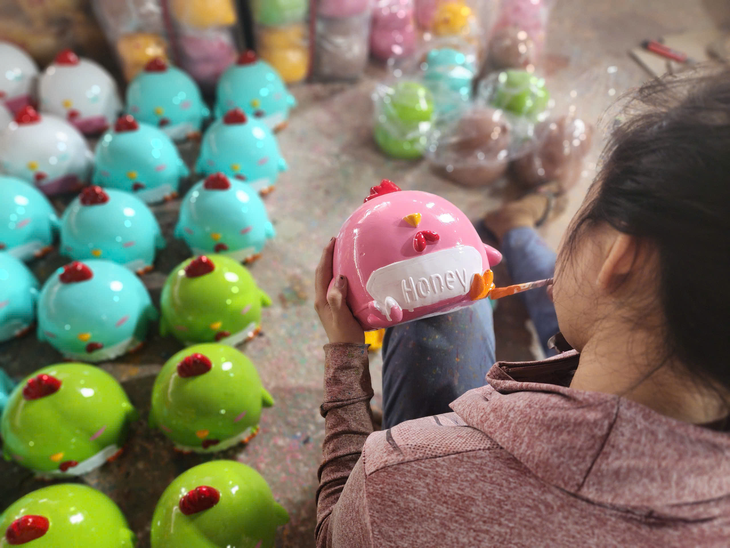 A worker paints a piggy bank of a cute cartoon character. Photo: Ngoc Phuong / Tuoi Tre News