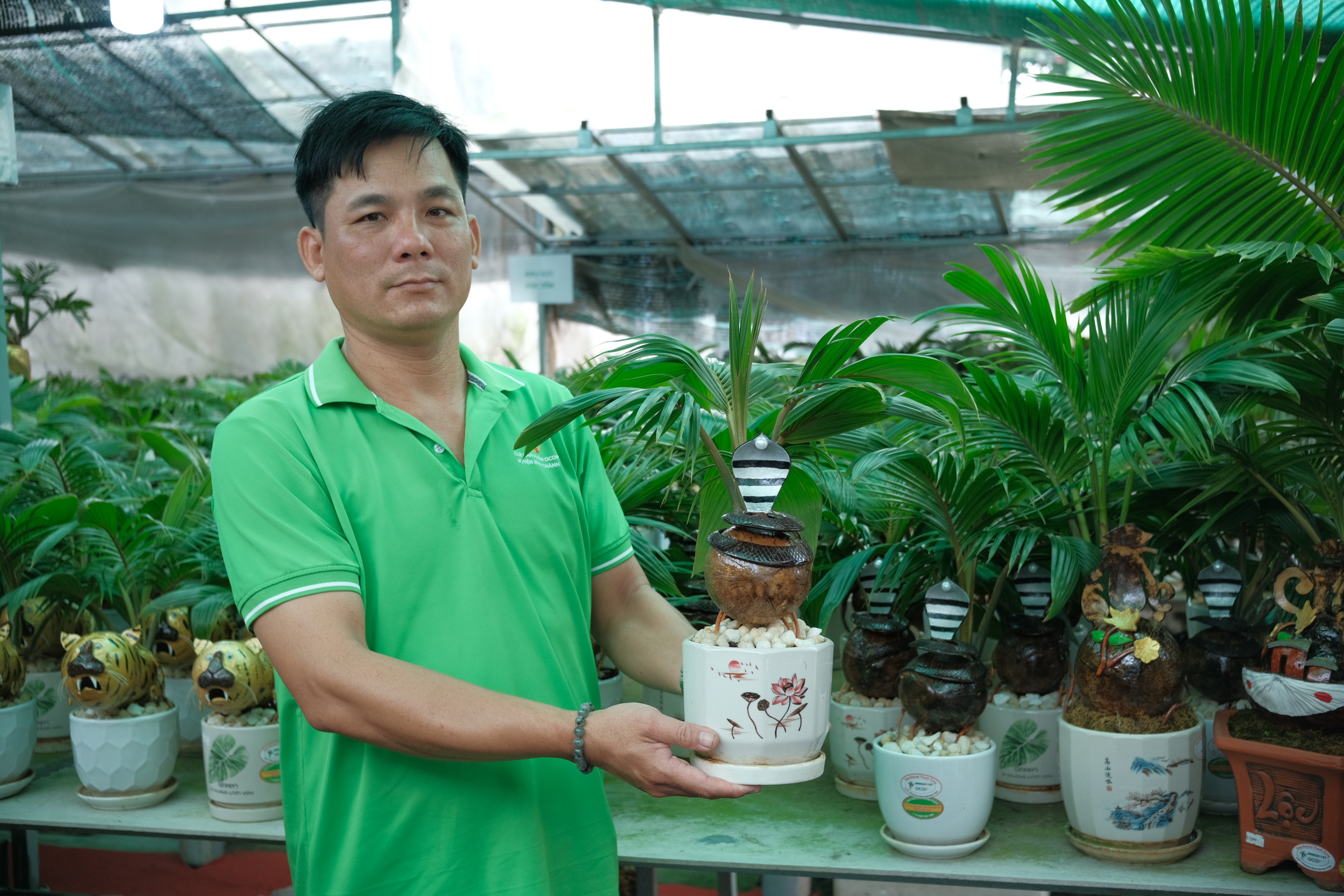 Tung poses with a coconut bonsai pot decorated with a snake sculpture. Photo: Ngoc Phuong / Tuoi Tre News