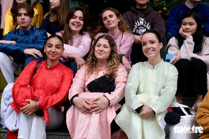 Hortense, (R, 1st, front row), a 20-year-old French student, and other international students wear ao dai during a Tet experience program at the Foreign Trade University in Hanoi, Vietnam, January 14, 2025. Photo: Nguyen Bao / Tuoi Tre