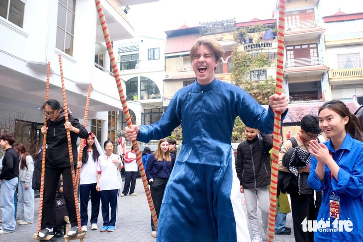 Jakob Christoph Winkler, a 22-year-old German student, expresses his excitement after successfully walking a long distance on stilts during a Tet experience program at the Foreign Trade University in Hanoi, Vietnam, January 14, 2025. Photo: Nguyen Bao / Tuoi Tre