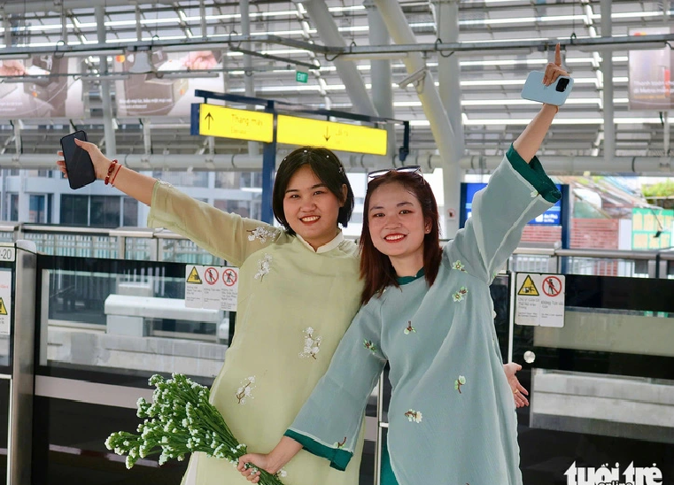 Nguyen Trinh (R), a 24-year-old resident in District 7, Ho Chi Minh City, shared that metro line No. 1 is a modern place and a great spot for taking photos. Photo: Be Hieu / Tuoi Tre