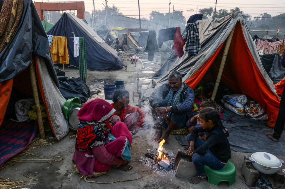 Hindu pilgrims sit outside temporary shelters on the eve of the start of the Maha Kumbh Mela festival in Prayagraj on January 12, 2025. Photo: AFP