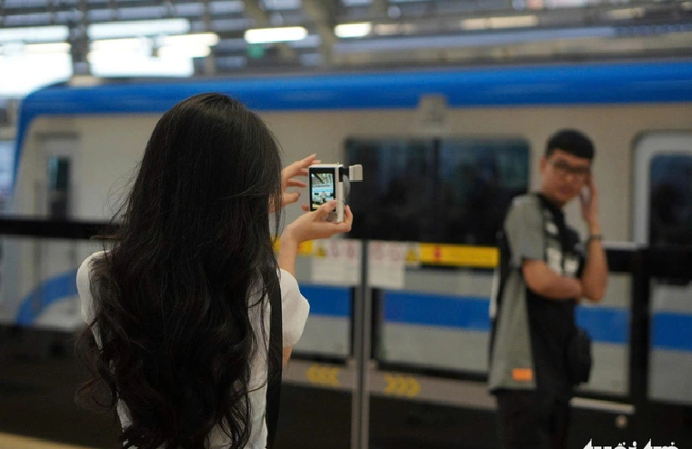 In addition to smartphones, many young people prefer using compact cameras to take photos at metro stations in Ho Chi Minh City. Photo: Xuan Huong / Tuoi Tre