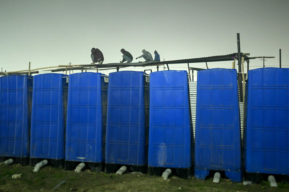 Workers fix the roof of temporary shelters on the eve of the start of the Maha Kumbh Mela festival in Prayagraj on January 12, 2025. Photo: AFP