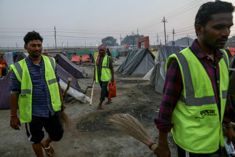 Sweepers return to their tents from work at a makeshift colony, built for sanitation workers, on a cold winter evening ahead of the Maha Kumbh Mela festival in Prayagraj on January 11, 2025. Photo: AFP