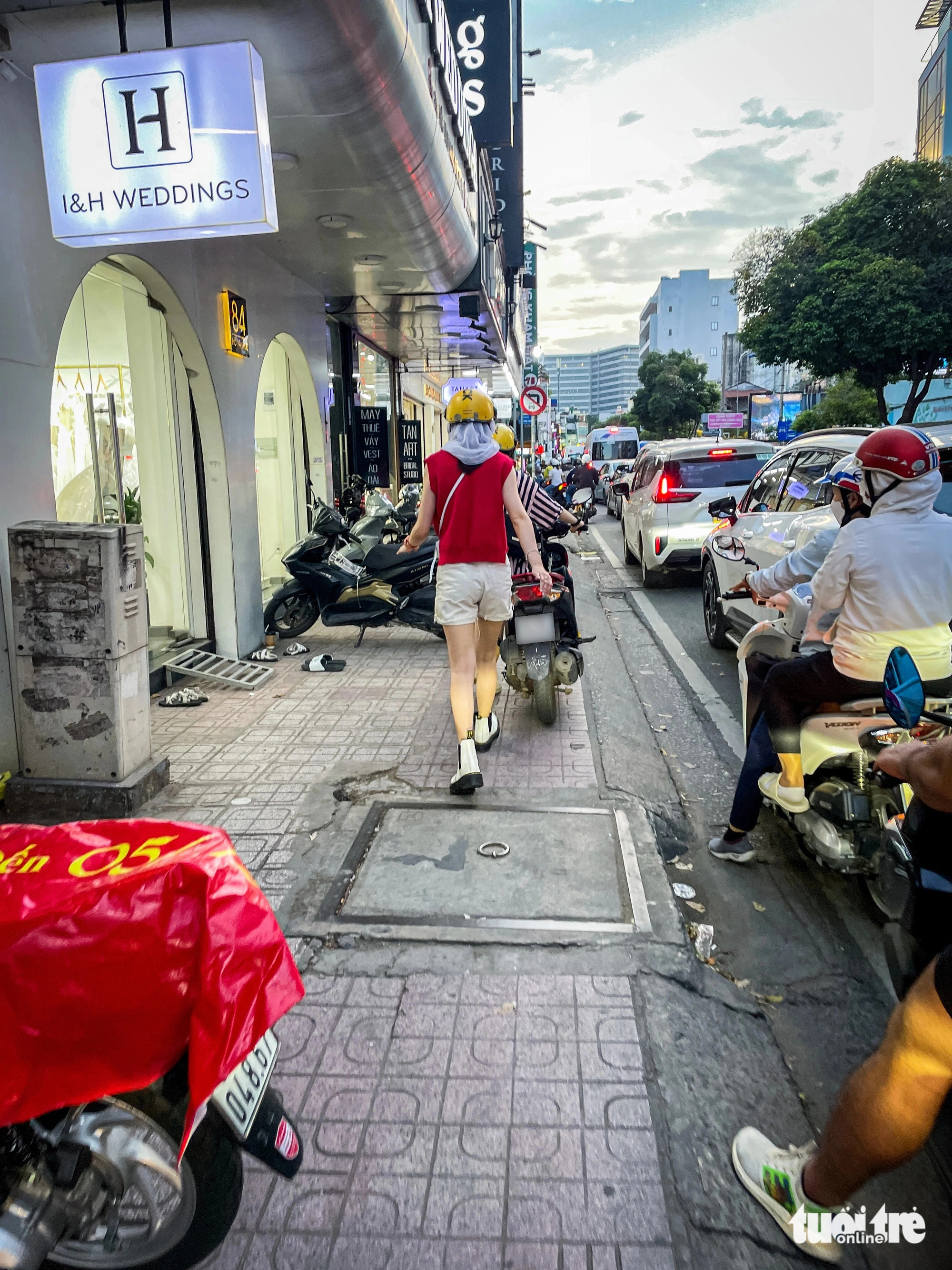 Riders push their motorcycles along sidewalks to escape traffic jams. Photo: Chau Tuan / Tuoi Tre