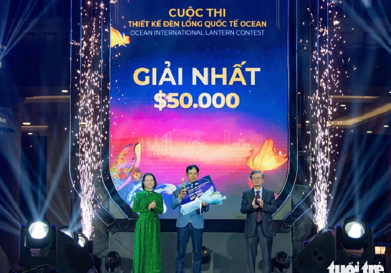 A representative of Hoi An Craft Vietnam (C) receives the first prize of the Ocean International Lantern Contest for the ‘Hon Thieng Dat Viet’ (The Sacred Soul of Vietnam) lantern.