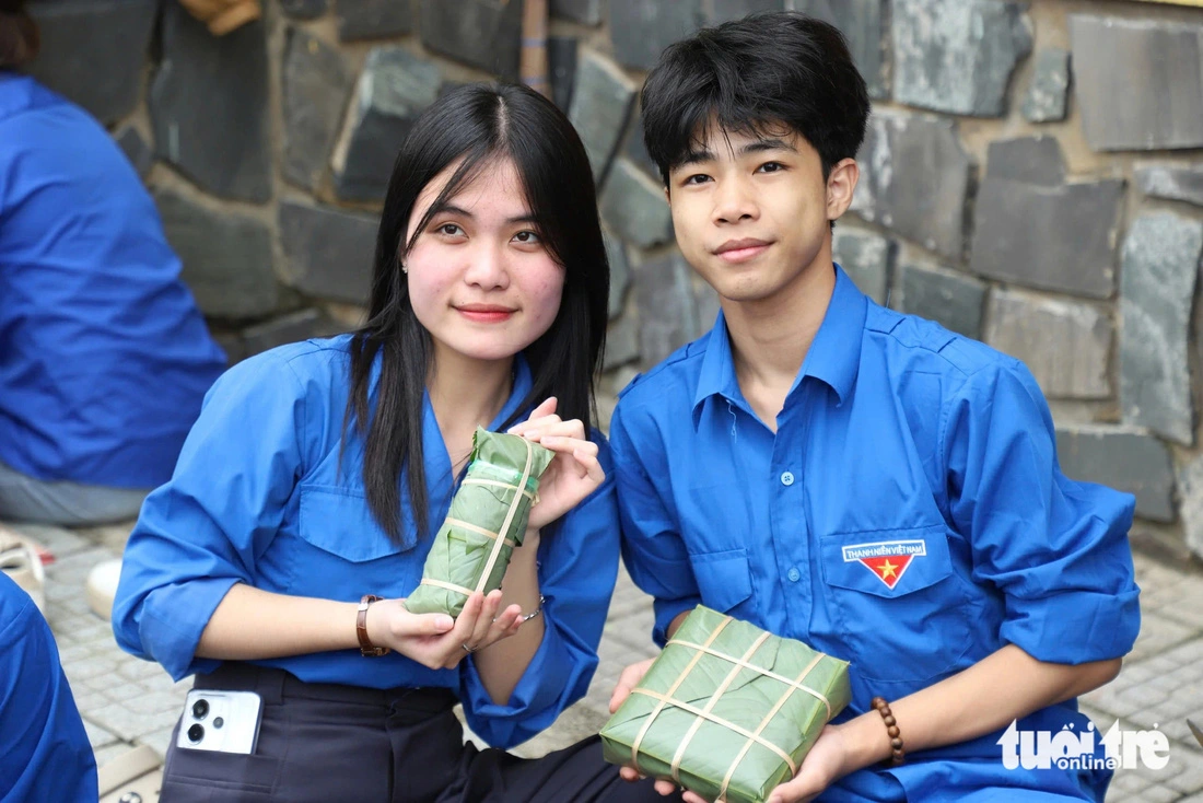 Two foreign students show off ‘banh chung’ and 'banh tet' (cylindrical glutinous rice cakes) wrapped beautifully by themselves.