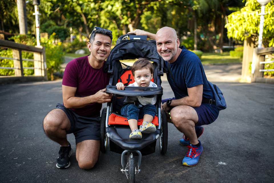 A gay couple, Surapong 'Keng' Koonpaew, 48, and Jacob Holder, 45, pose for photo with their son, Elijah Bprin Holder Koonpaew, at a park in Bangkok, Thailand, January 11, 2025. Photo: Reuters