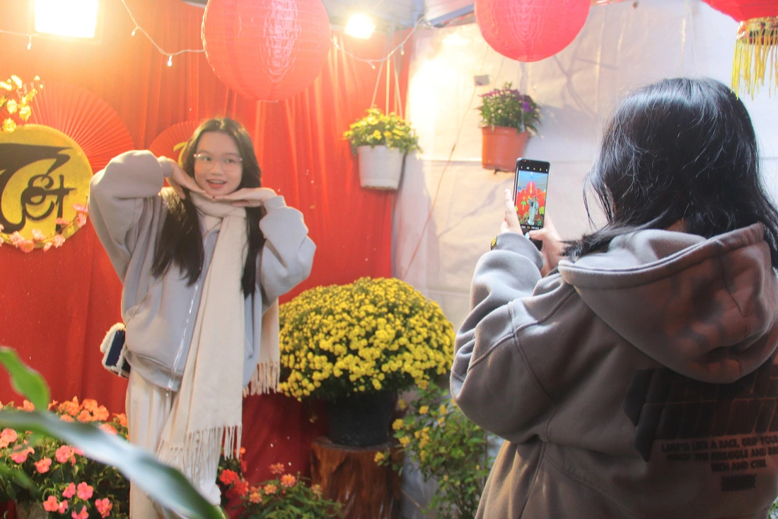 A young girl poses for a photo at a Tet-themed decorated corner in Da Nang City. Photo: Thanh Thuy / Tuoi Tre