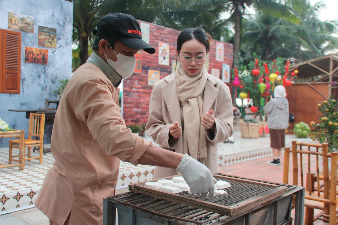 A tourist experiences making ‘banh in’ (snow-flaked cakes) in Da Nang City. Photo: Thanh Thuy / Tuoi Tre