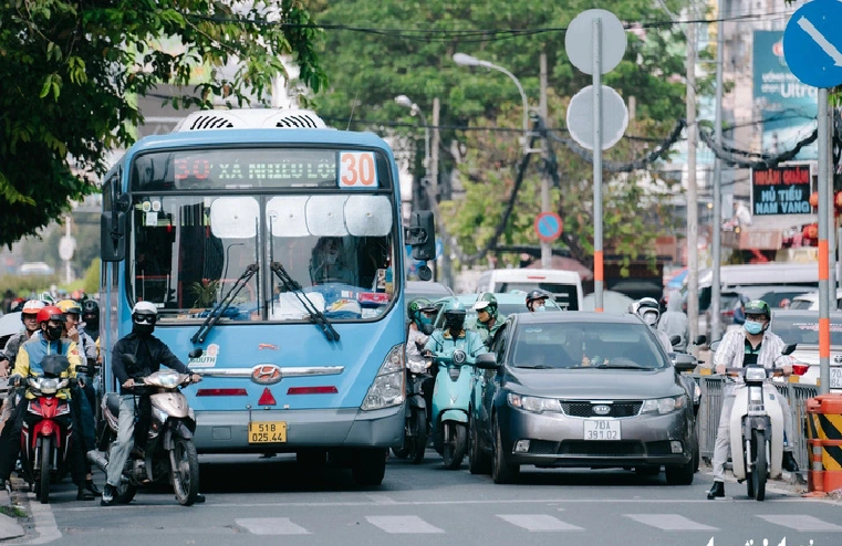 As their lanes are encroached, many motorcyclists thread their way among cars waiting at a red light on Cach Mang Thang Tam Street in District 3, Ho Chi Minh City, January 17, 2025. Photo: Thanh Hiep / Tuoi Tre