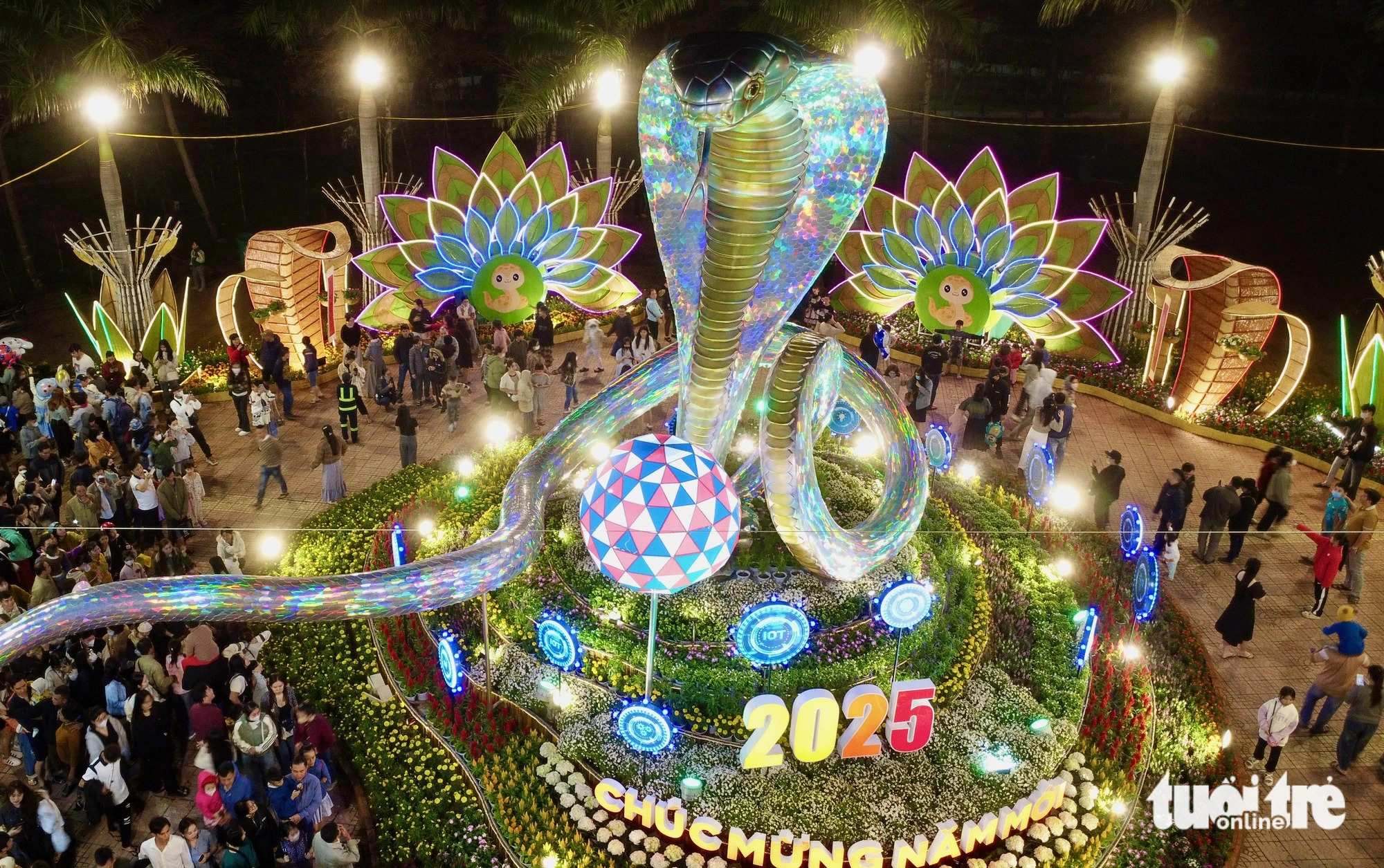 The centerpiece of the flower street features a snake mascot cradling an Internet globe and surrounded by AI-inspired installations. Photo: Minh Chien / Tuoi Tre