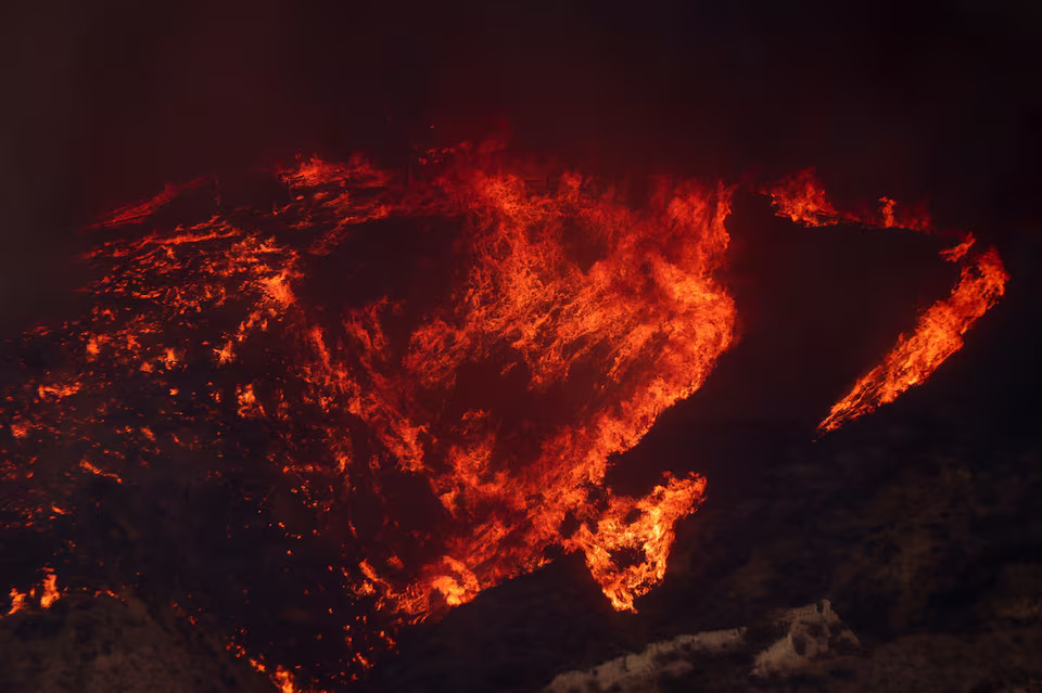 [5/13]Smoke and flames rise as firefighters and aircraft battle the Hughes Fire near Castaic Lake, north of Santa Clarita, California, U.S. January 22, 2025. Photo: Reuters