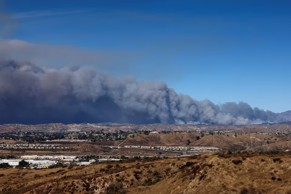 [11/13]A cloud of smoke from the Hughes Fire rises as firefighters and aircraft battle it near Castaic Lake, north of Santa Clarita, as seen from a highway nearby, California, U.S. January 22, 2025. Photo: Reuters