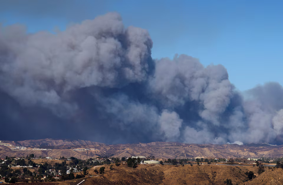 [13/13]A cloud of smoke from the Hughes Fire rises as firefighters and aircraft battle it near Castaic Lake, north of Santa Clarita, as seen from a highway nearby, California, U.S. January 22, 2025. Photo: Reuters