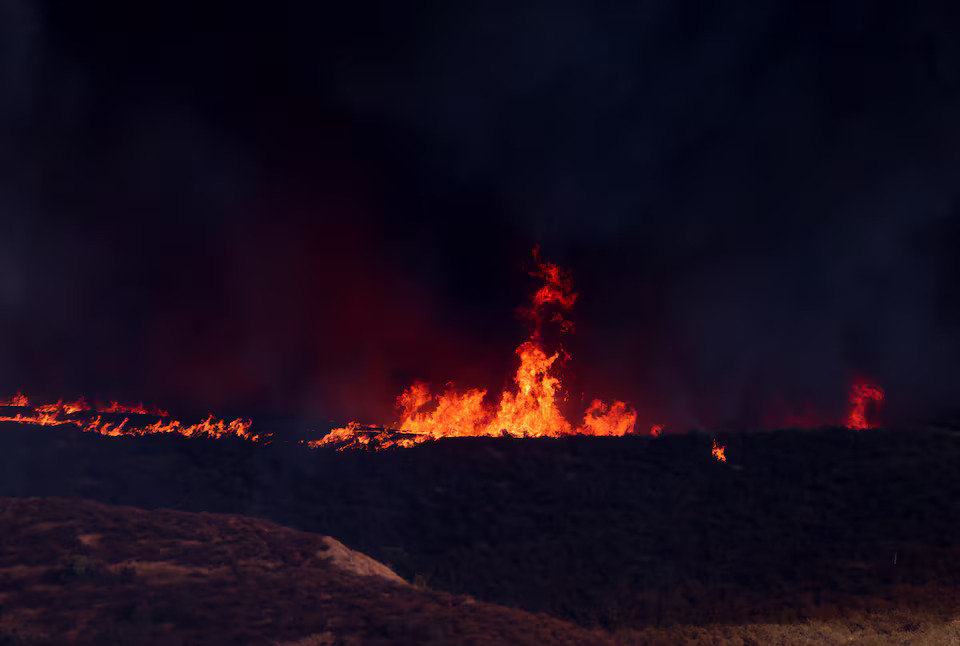 [8/13]Flames from the Hughes Fire rise as firefighters and aircraft battle it, near Castaic Lake, north of Santa Clarita, California, U.S. January 22, 2025. Photo: Reuters