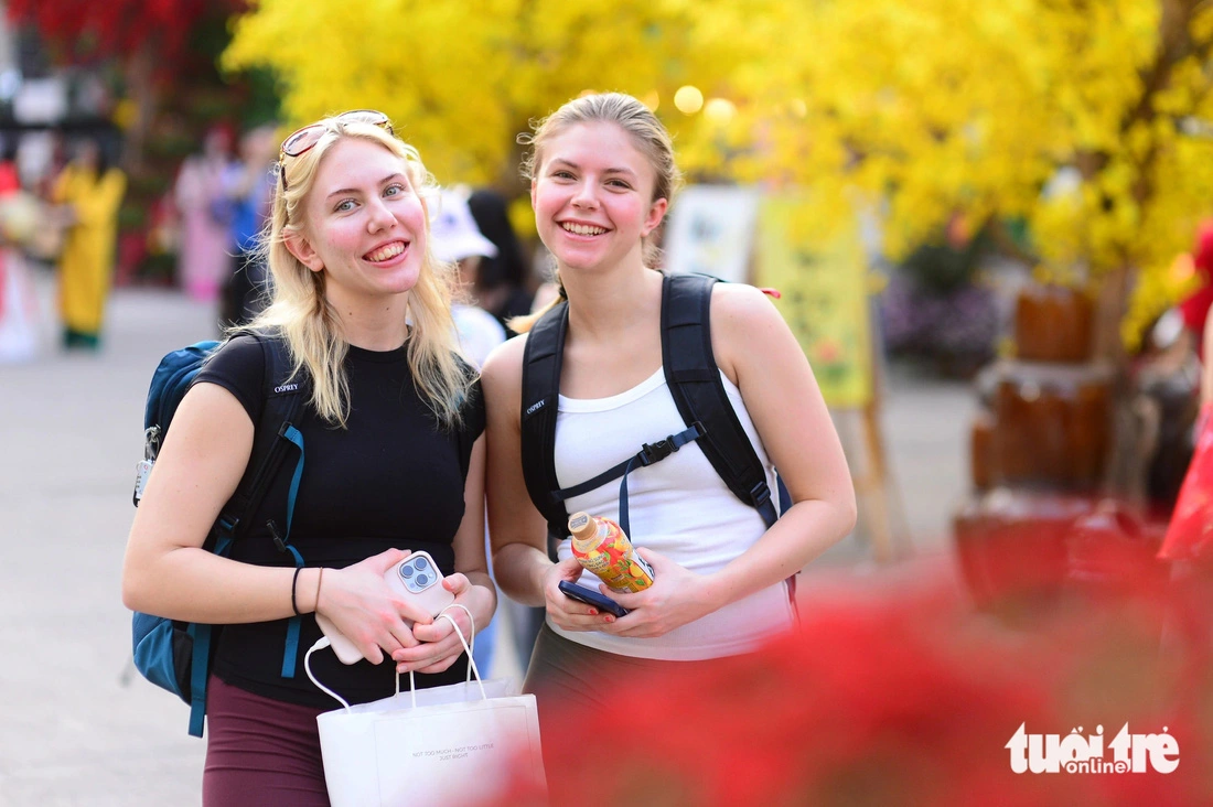 Two Swiss tourists experience the 2025 Vietnamese Tet Festival at the Youth Culture House in Ho Chi Minh City, January 13, 2024.