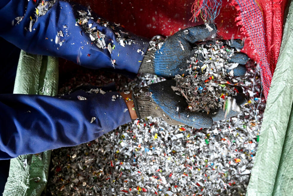 This photograph taken on December 26, 2024 shows a worker holding shredded recyclable plastic waste at the Green Road Waste Management processing facility in Pokhara. Photo: AFP