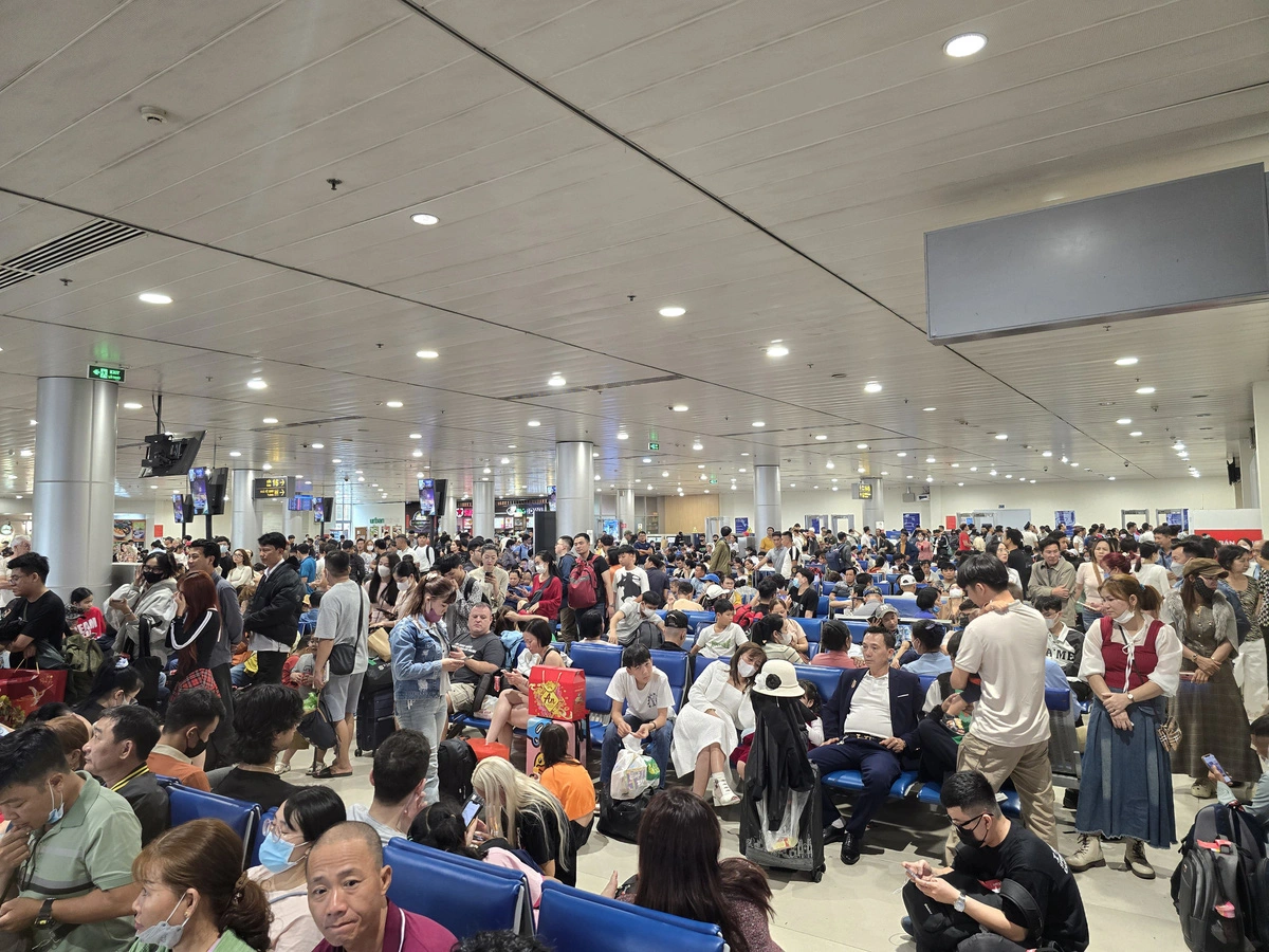 This image features many passengers forced to stand or squat on the floor as all the seats were occupied at the overcrowded domestic terminal of Tan Son Nhat International Airport in Ho Chi Minh City, January 24, 2025. Photo: Cong Trung / Tuoi Tre