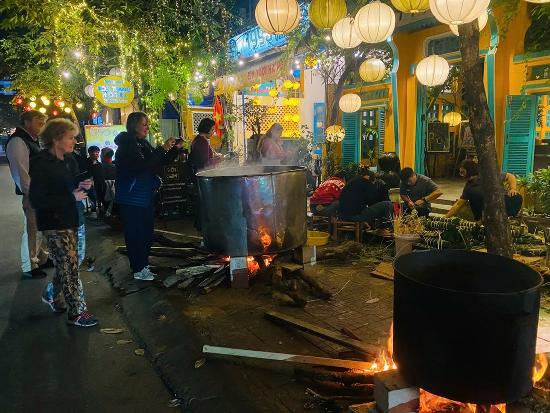 Pots of 'banh chung' and 'banh tet' were cooked at Boi Com Hoi An Restaurant & Café in Hoi An City, Quang Nam Province, central Vietnam, with the participation of many foreign travelers. Photo: Nhan Quy