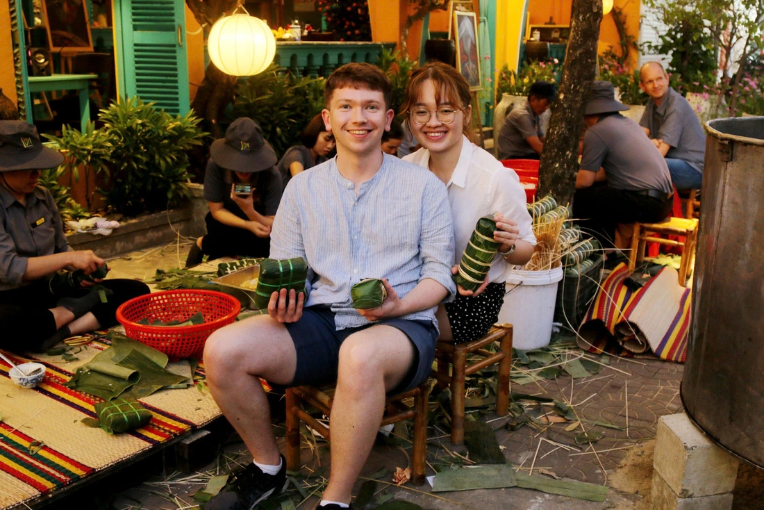 Two international tourists are seen holding the 'banh chung' and 'banh tet' they made themselves at Boi Com Hoi An Restaurant & Café in Hoi An City, Quang Nam Province, central Vietnam. Photo: Nhan Quy