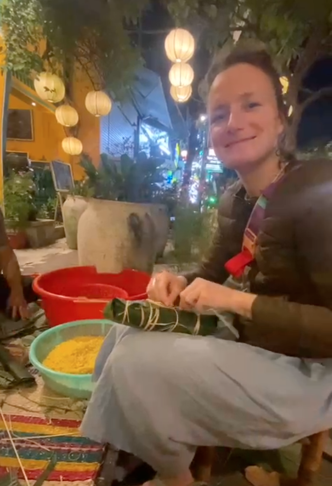 A foreign woman poses for a photo while enjoying wrapping a 'banh tet' at Boi Com Hoi An Restaurant & Café in Hoi An City, Quang Nam Province, central Vietnam. Photo: Nhan Quy