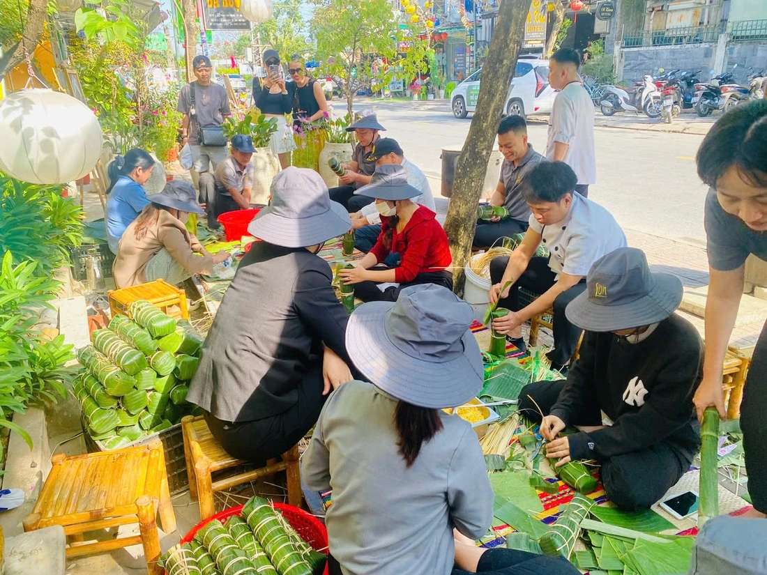 This image shows part of the scene of wrapping 'banh chung' and 'banh tet' in the front yard of Boi Com Hoi An Restaurant & Café in Hoi An City, Quang Nam Province, central Vietnam. Photo: Nhan Quy