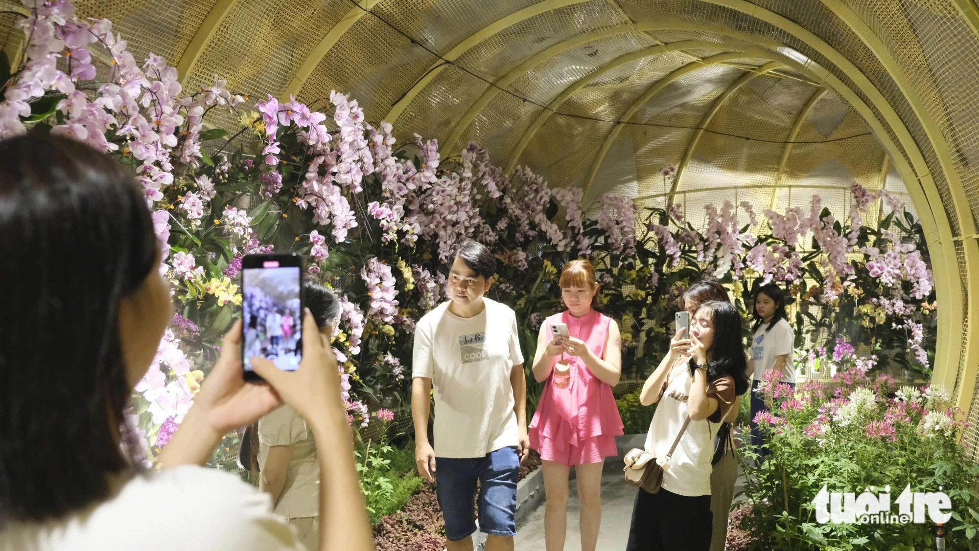 Visitors pose with vibrant orchid displays at the Tet flower street in Cao Lanh City, Dong Thap Province, southern Vietnam, January 25, 2025. Photo: Dang Tuyet / Tuoi Tre