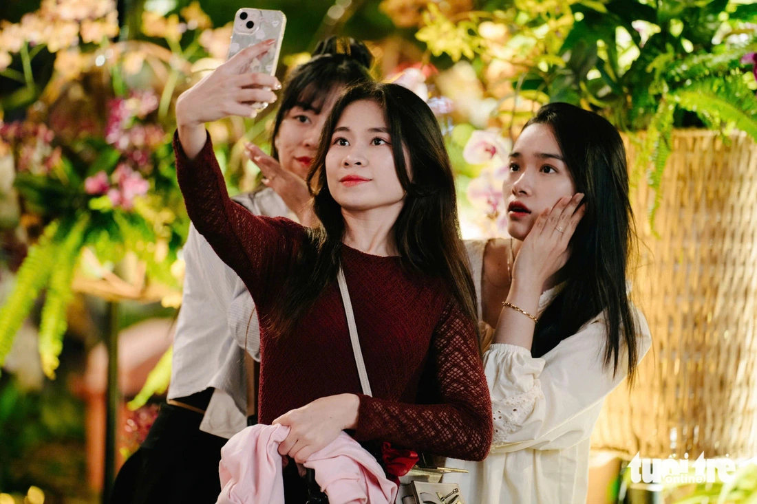 Young people take commemorative photos at Nguyen Hue Flower Street on Lunar New Year's Eve. Photo: Thanh Hiep / Tuoi Tre