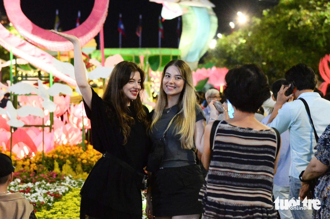 Two French female tourists take a commemorative photo at Nguyen Hue Flower Street in Ho Chi Minh City, January 28, 2025. Photo: Hai Quynh