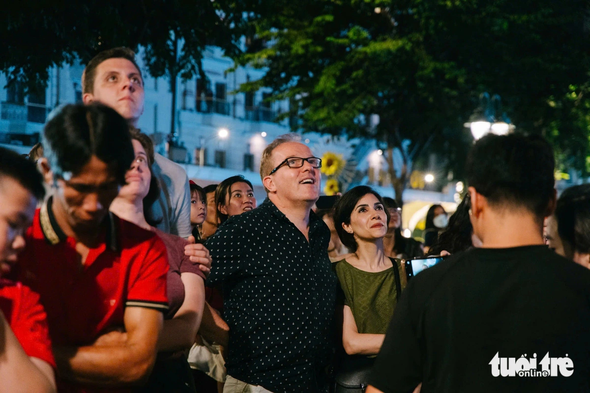 Johnson (C), an American tourist, is impressed by the high-altitude fireworks in Ho Chi Minh City. Photo: Thanh Hiep / Tuoi Tre