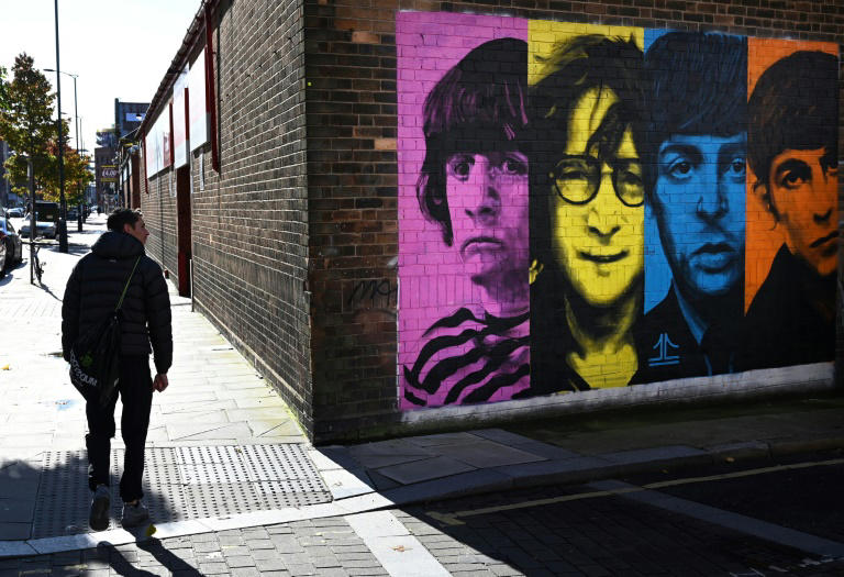 Pedestrians pass a mural depicting members of British rock band The Beatles (L-R) Ringo Starr, John Lennon, Paul McCartney and George Harrison on the side of a building in Liverpool, northwest England on October 13, 2020, as new local lockdown measures are set to be imposed to help stem a second wave of the novel coronavirus COVID-19. Photo: AFP