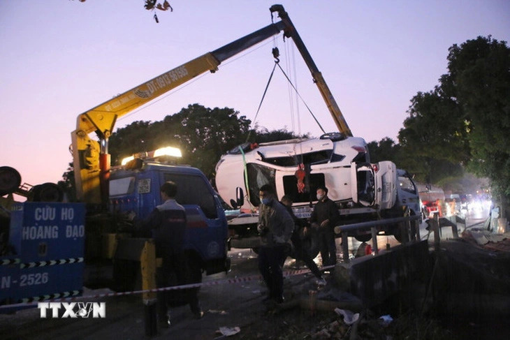 A rescue crane truck is seen lifting the stranded car from the Nam Van River on National Highway 21 in Nam Dinh Province, northern Vietnam, January 30, 2025. Photo: Hong Quang / Tuoi Tre