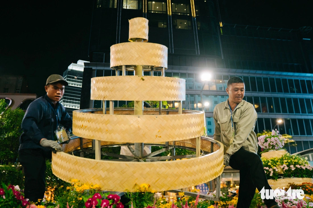 Workers remove the ‘flower cake’ miniature from Nguyen Hue Flower Street in Ho Chi Minh City. Photo: Thanh Hiep / Tuoi Tre