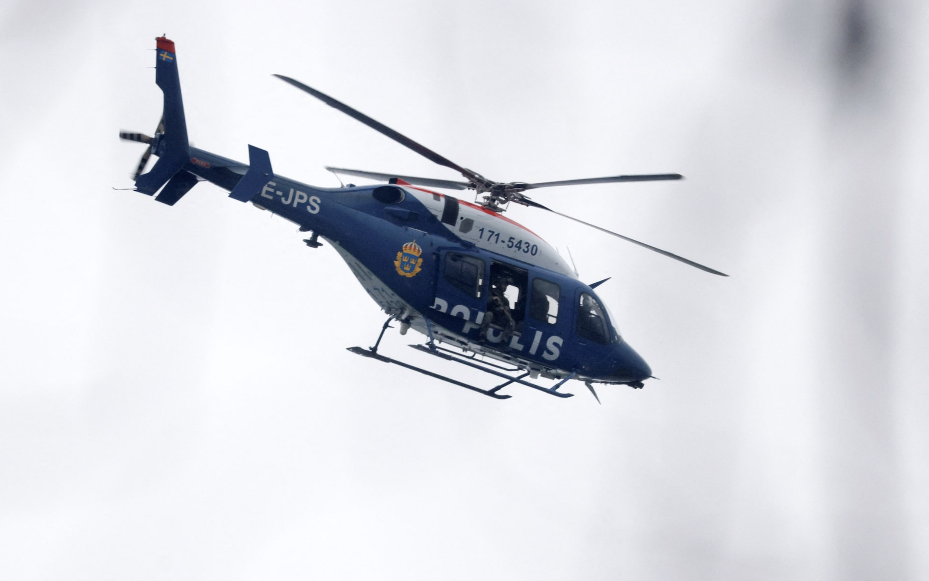 A police helicopter flies as a major police operation is underway at Risbergska School, following reports of a serious violent crime, in Orebro, Sweden, February 4, 2025. Photo: Reuters