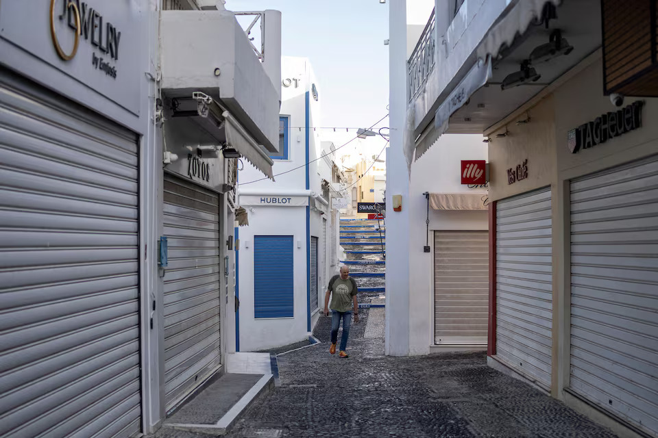 [7/20]A man walks between closed tourist shops on the island of Santorini, February 4. Photo: Reuters