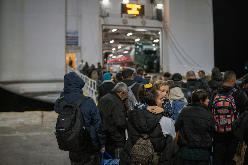 [20/20]A woman carries her daughter as people board a ferry during increased seismic activity on the island of Santorini, February 4. Photo: Reuters