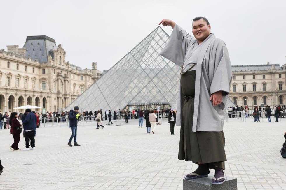 The Rikishis, Tochitaikai Yu poses for a photo in front of the Louvre Pyramids, in Paris on February 5, 2025. Photo: AFP