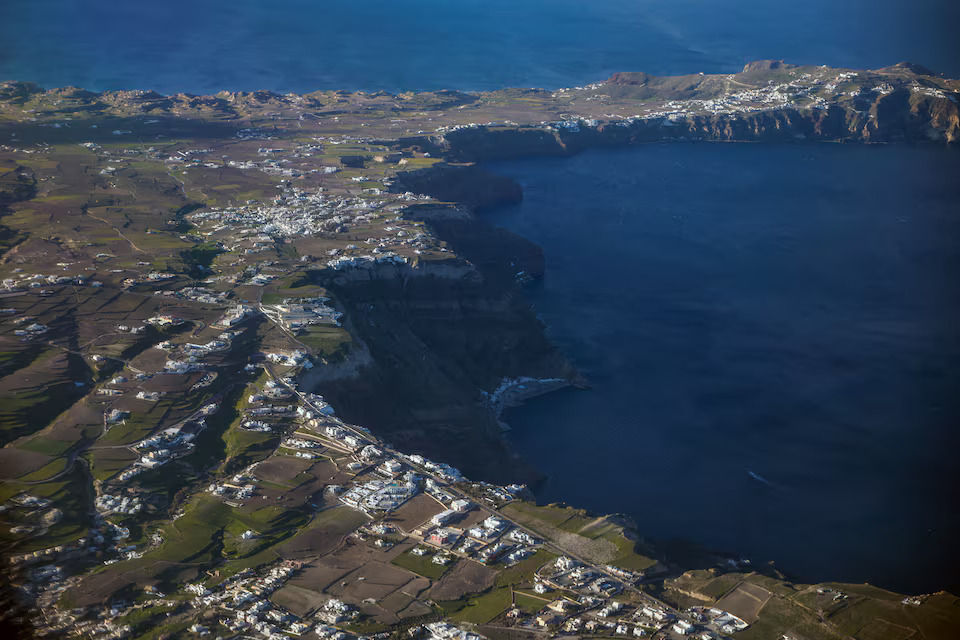 [8/9]A photo taken through the window of an airplane shows part of the caldera of Santorini, as the increased seismic activity continues on the island of Santorini, Greece, February 7, 2025. Photo: Reuters