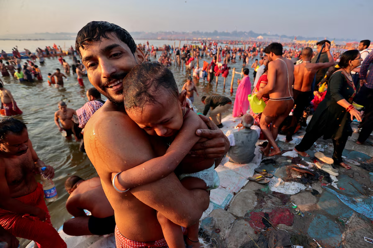 A devotee holds a child as they leave after taking a dip at Sangam, the confluence of the Ganges and Yamuna rivers with the mythical invisible Saraswati river, to mark Maghi Purnima, one of the auspicious days during the 'Maha Kumbh Mela', or the Great Pitcher Festival, in Prayagraj, India, February 12, 2025.  Photo: Reuters