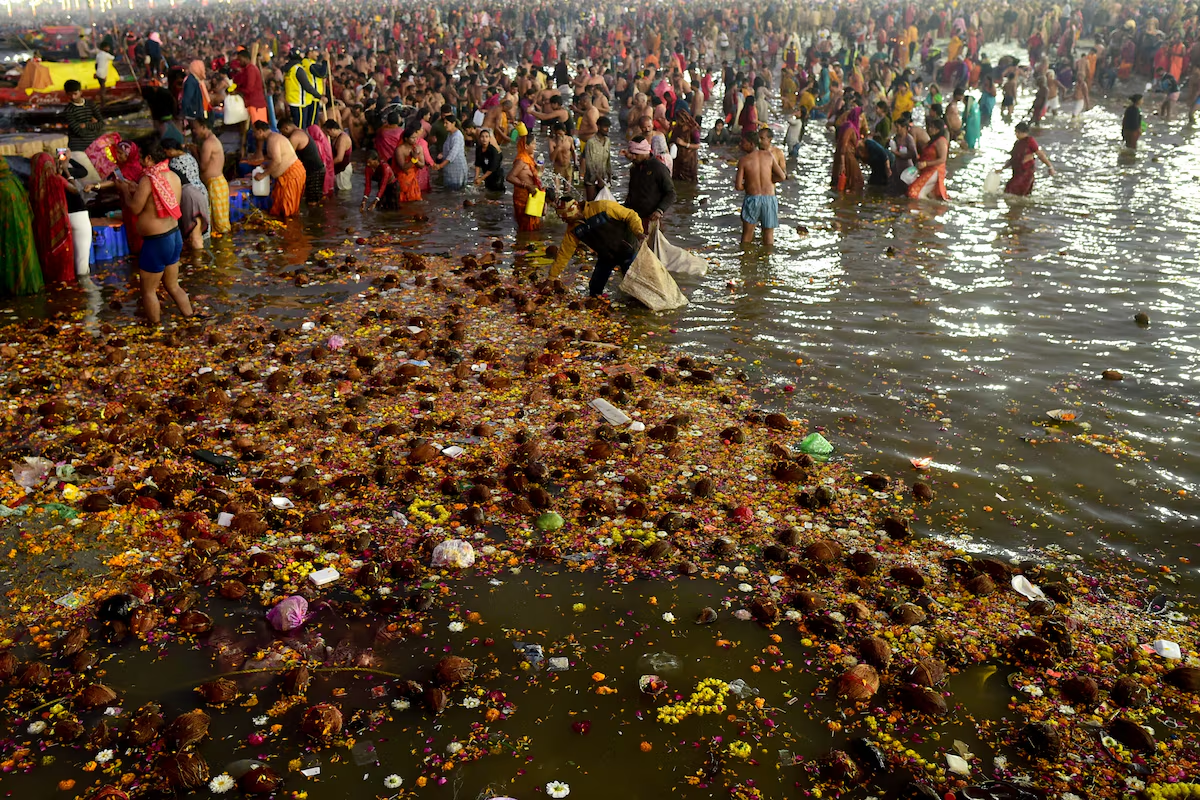 A man collects coconuts thrown in as offerings by devotees at Sangam, the confluence of the Ganges and Yamuna rivers with the mythical invisible Saraswati river, to mark Maghi Purnima, one of the auspicious days during the 'Maha Kumbh Mela', or the Great Pitcher Festival, in Prayagraj, India, February 12, 2025. Photo: Reuters