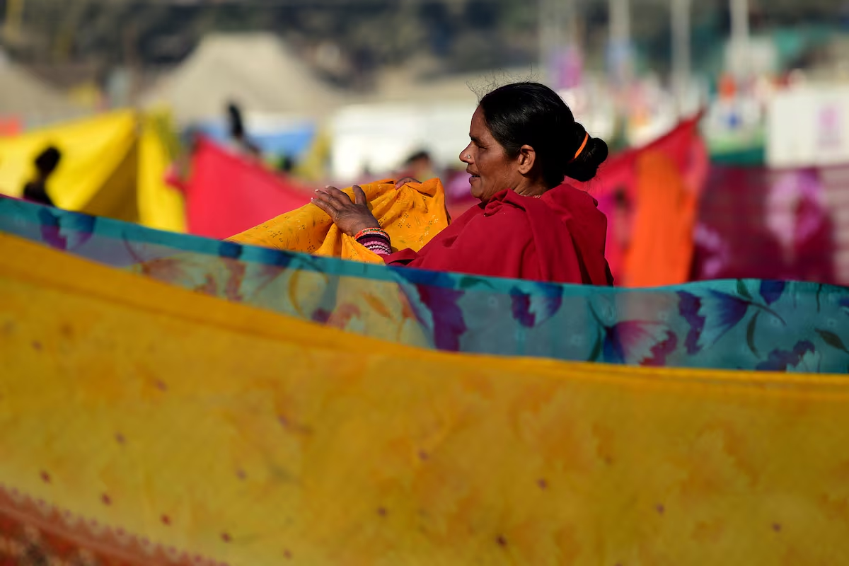 A devotee dries sarees after taking a dip at Sangam, the confluence of the Ganges and Yamuna rivers with the mythical, invisible Saraswati river, to mark Maghi Purnima, one of the auspicious days during the 'Maha Kumbh Mela', or the Great Pitcher Festival, in Prayagraj, India, February 12, 2025. Photo: Reuters