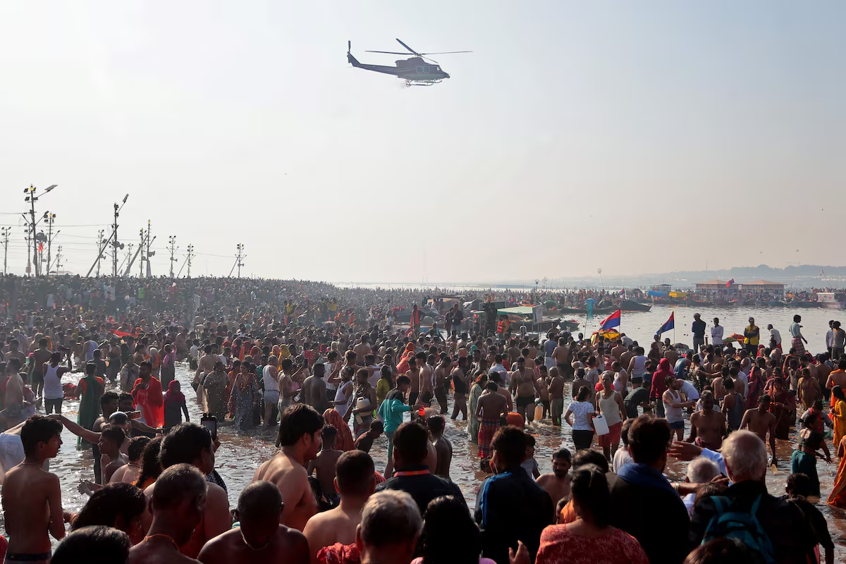 A helicopter drops flower petals on the devotees taking a dip at Sangam, the confluence of the Ganges and Yamuna rivers with the mythical invisible Saraswati river, to mark Maghi Purnima, one of the auspicious days during the 'Maha Kumbh Mela', or the Great Pitcher Festival, in Prayagraj, India, February 12, 2025. Photo: Reuters