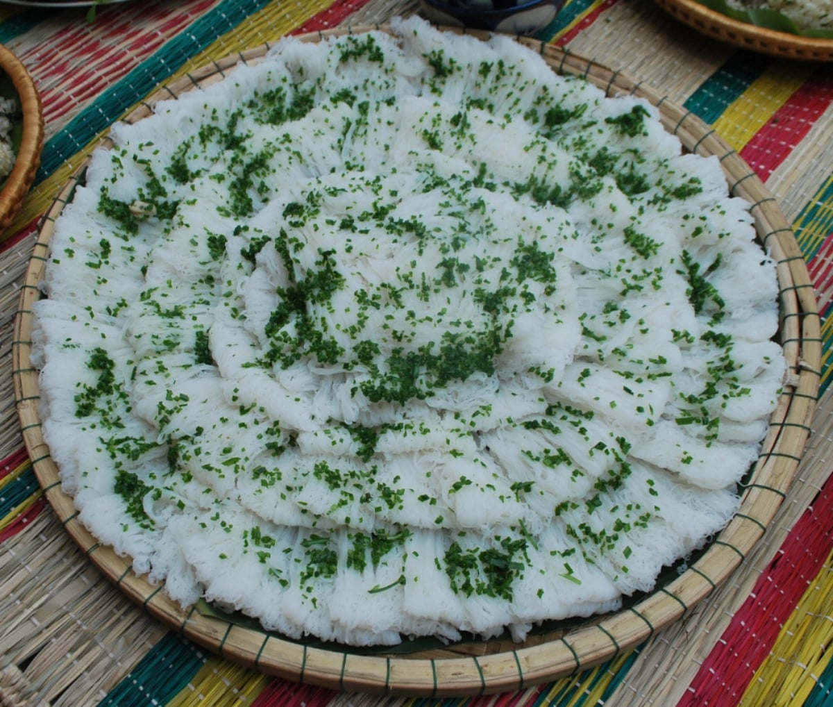 A plate of 'bánh hỏi' topped with chopped garlic chives. Photo: Hoa Vang / Tuoi Tre