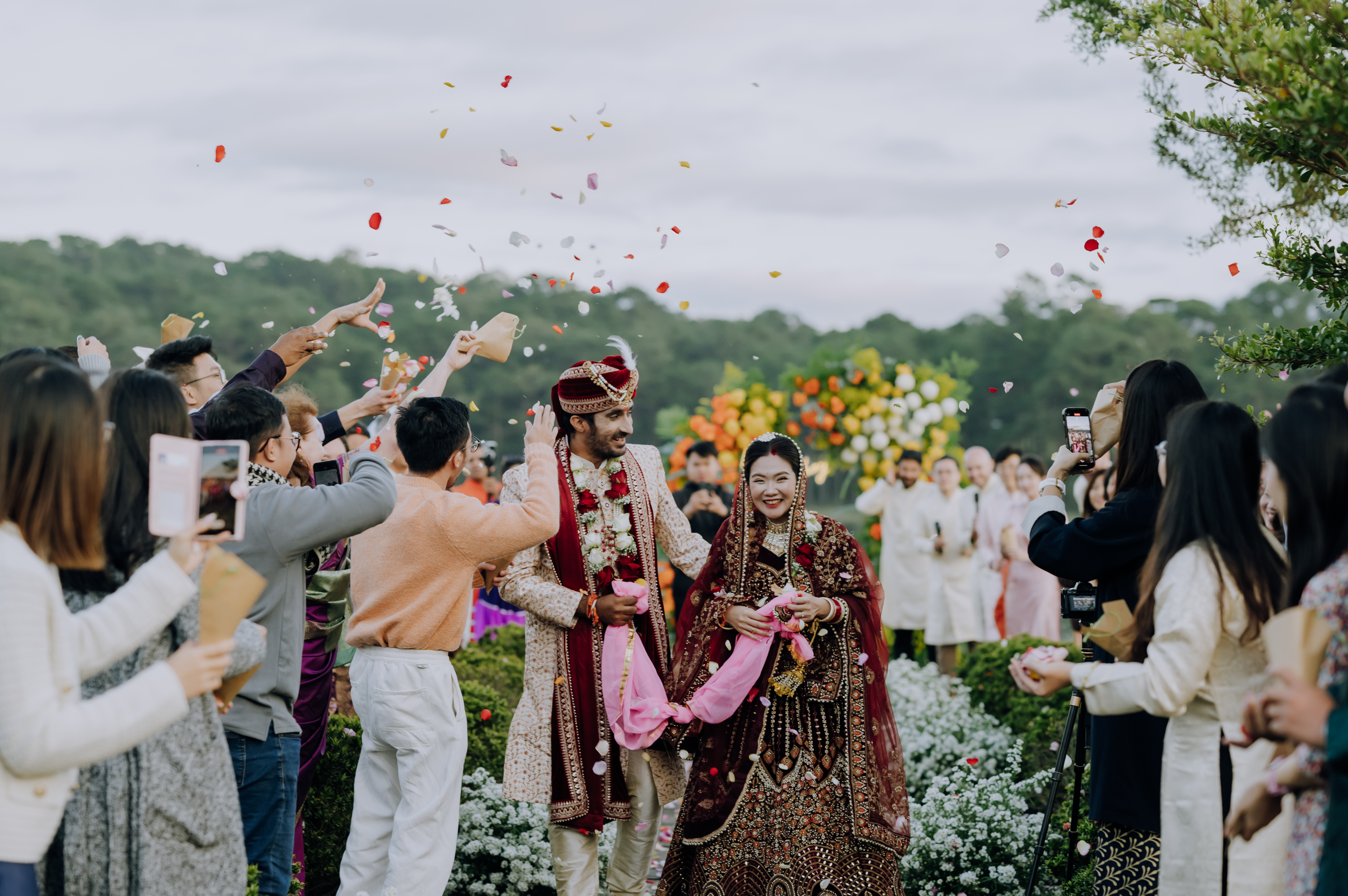 Akshay Sharma and his wife, dressed in traditional Indian attire, celebrate their wedding surrounded by guests. Photo courtesy of Akshay Sharma.