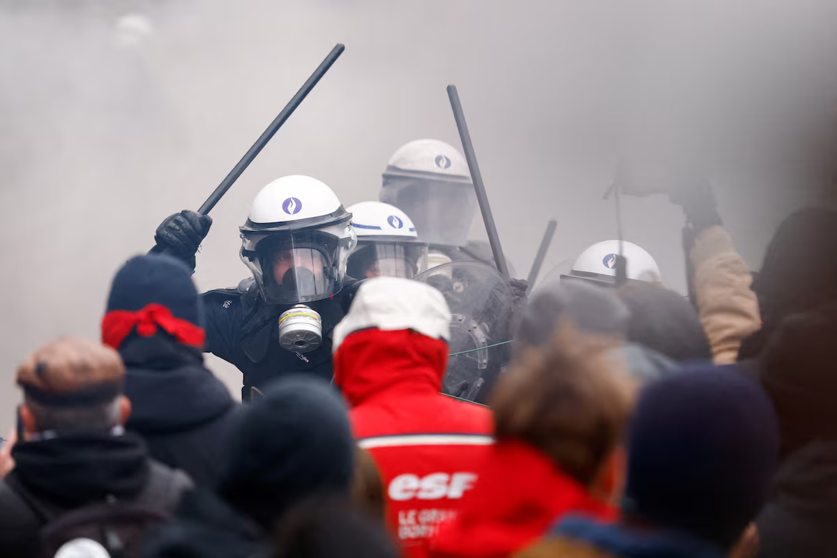 Riot police wield their batons as they confront demonstrators at a national strike by workers and trade union members demanding stronger public services in Brussels, Belgium, February 13. Photo: Reuters