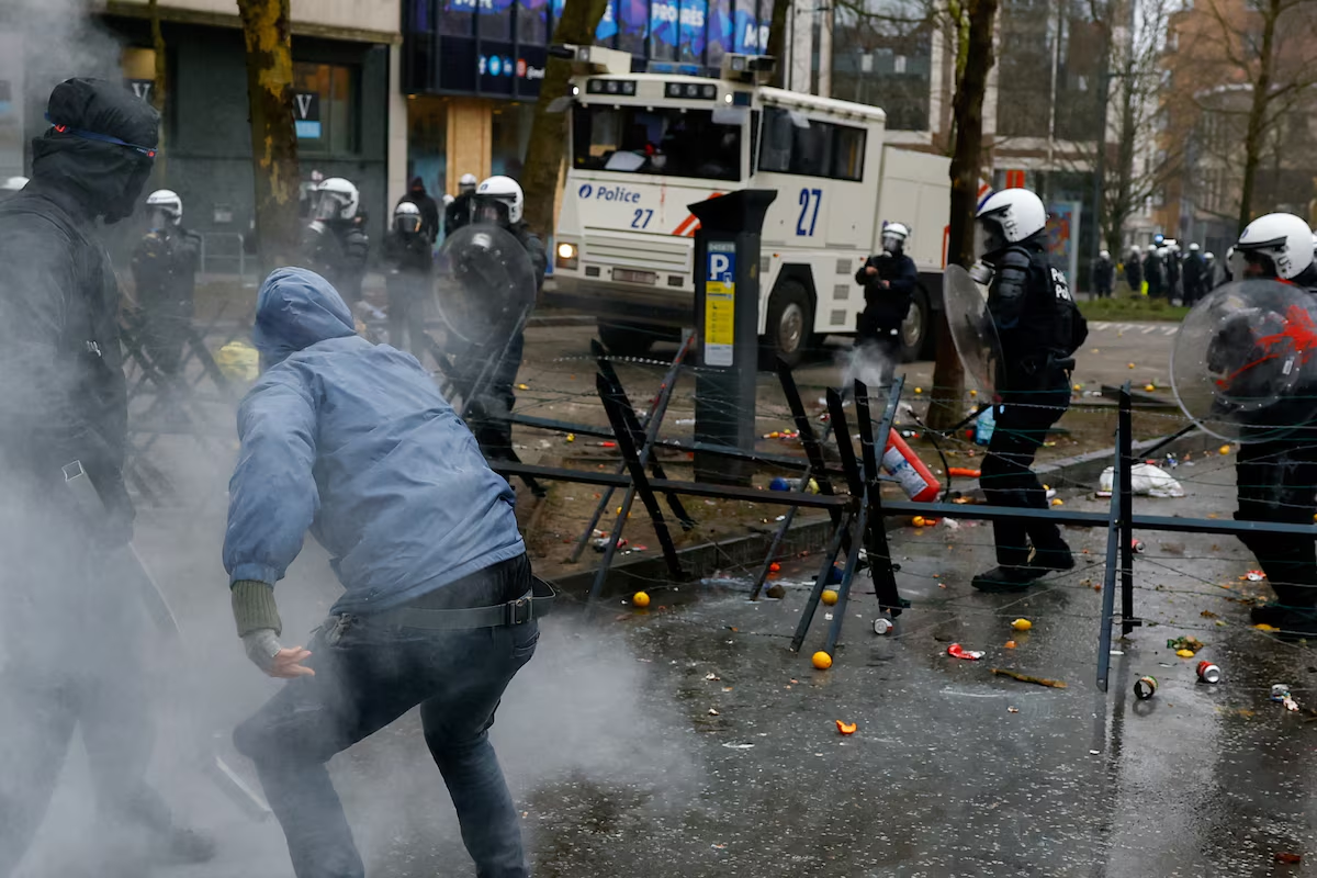 A protester throws fire extinguisher at riot police, as another approaches with a metal bar, at a national strike by workers and trade union members, who are demanding stronger public services in Brussels, Belgium February 13, 2025. Photo: Reuters