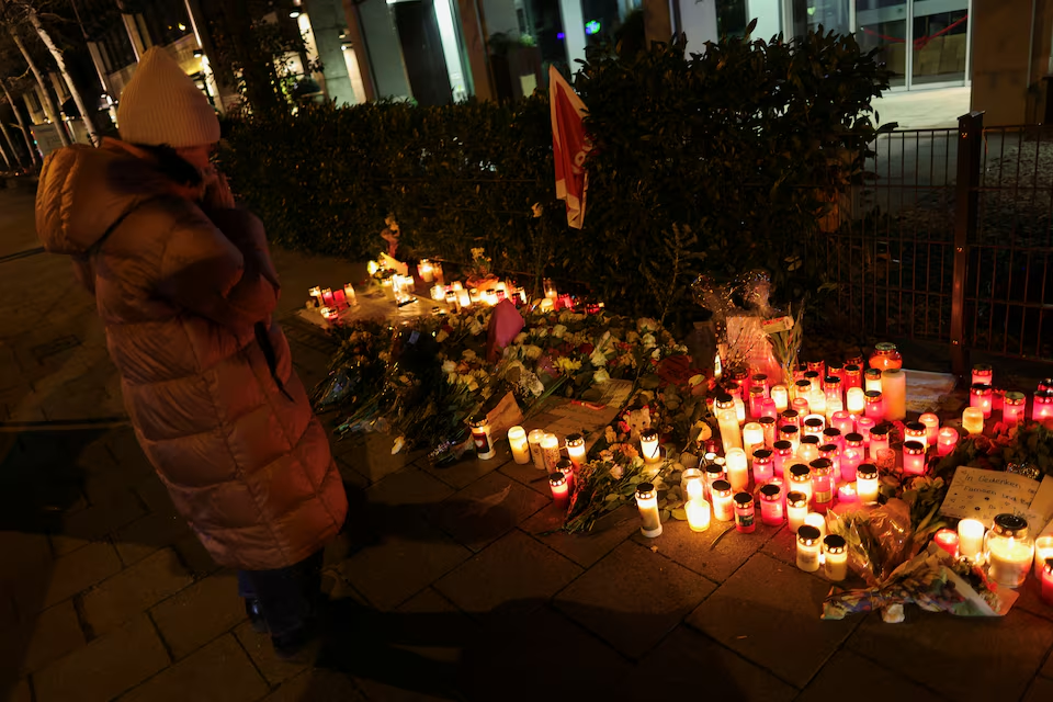 A woman looks at tributes at a makeshift memorial for the victims of a suspected ramming attack where a 24-year-old Afghan asylum seeker drove a car into a crowd, in Munich, Germany February 15, 2025. Photo: Reuters